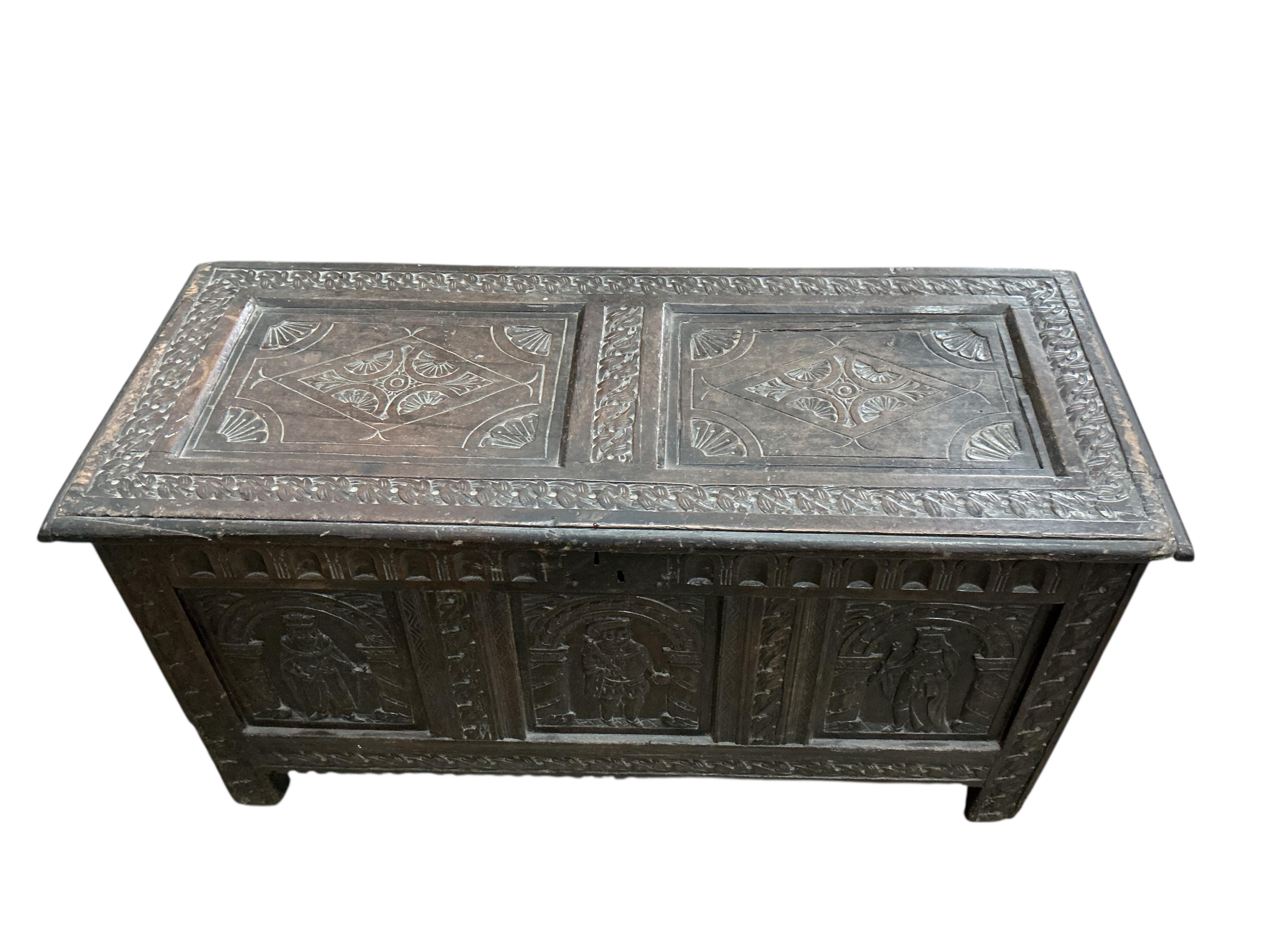 An 18th century oak panelled coffer, later carved, width 116cm, depth 49cm, height 64cm